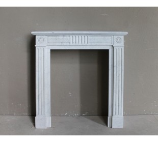 Grazioso camino antico neoclassico di piccola taglia in marmo bianco con dettagli scultorei floreali molto eleganti.