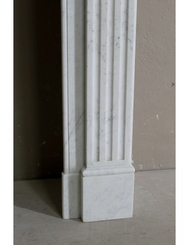 Grazioso camino antico neoclassico di piccola taglia in marmo bianco con dettagli scultorei floreali molto eleganti.