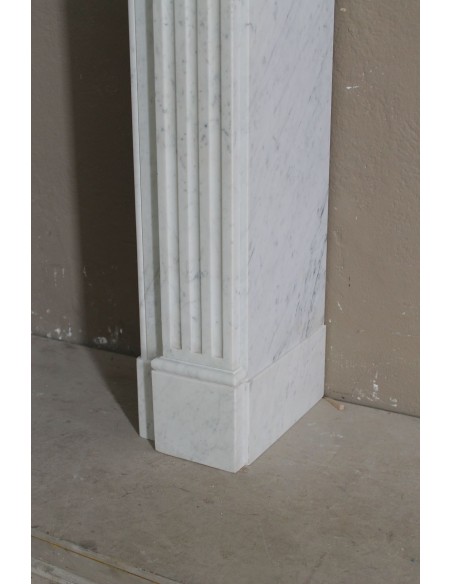 Grazioso camino antico neoclassico di piccola taglia in marmo bianco con dettagli scultorei floreali molto eleganti.