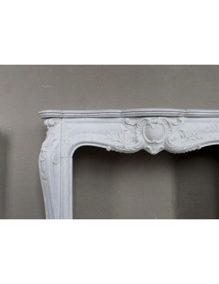 Camino antico in marmo bianco di stile barocco e d'epoca ottocentesca con decori floreali e sculture raffinate.