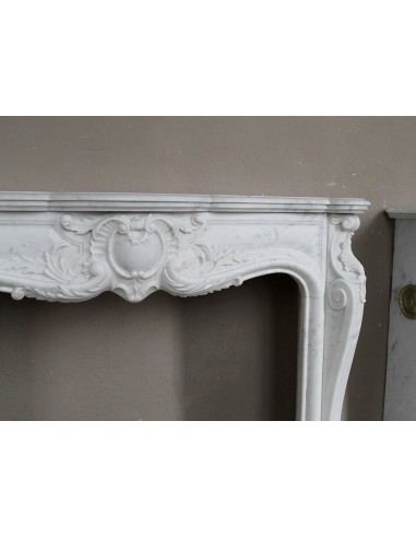 Camino antico in marmo bianco di stile barocco e d'epoca ottocentesca con decori floreali e sculture raffinate.