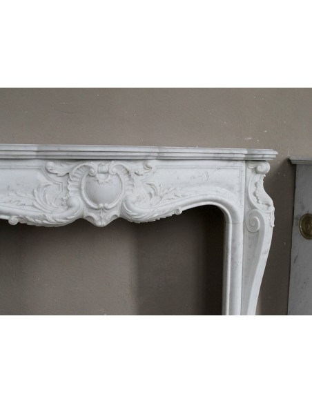 Camino antico in marmo bianco di stile barocco e d'epoca ottocentesca con decori floreali e sculture raffinate.