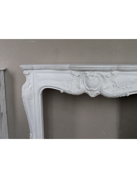 Camino antico in marmo bianco di stile barocco e d'epoca ottocentesca con decori floreali e sculture raffinate.