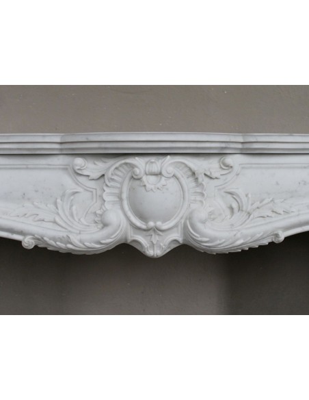 Camino antico in marmo bianco di stile barocco e d'epoca ottocentesca con decori floreali e sculture raffinate.