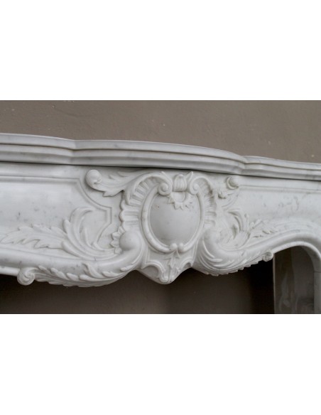 Camino antico in marmo bianco di stile barocco e d'epoca ottocentesca con decori floreali e sculture raffinate.