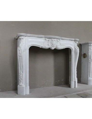 Camino antico in marmo bianco di stile barocco e d'epoca ottocentesca con decori floreali e sculture raffinate.