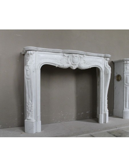 Camino antico in marmo bianco di stile barocco e d'epoca ottocentesca con decori floreali e sculture raffinate.