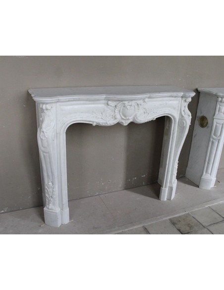 Camino antico in marmo bianco di stile barocco e d'epoca ottocentesca con decori floreali e sculture raffinate.