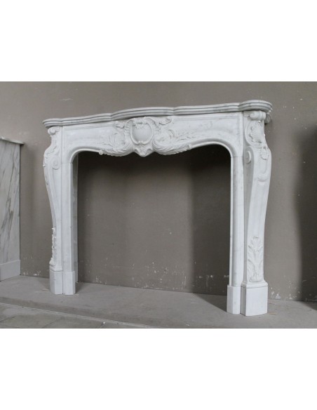 Camino antico in marmo bianco di stile barocco e d'epoca ottocentesca con decori floreali e sculture raffinate.