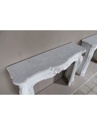 Camino antico in marmo bianco di stile barocco e d'epoca ottocentesca con decori floreali e sculture raffinate.