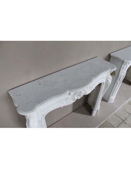 Camino antico in marmo bianco di stile barocco e d'epoca ottocentesca con decori floreali e sculture raffinate.