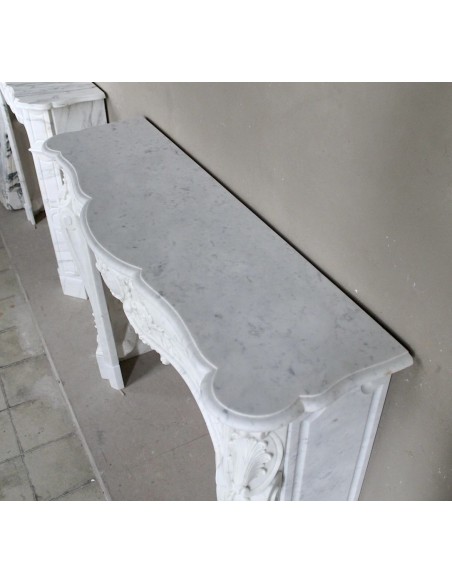 Camino antico in marmo bianco di stile barocco e d'epoca ottocentesca con decori floreali e sculture raffinate.