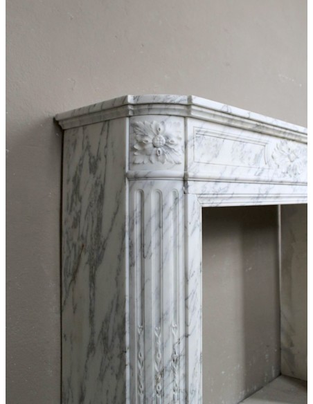 Caminetto neoclassico scolpito in marmo Statuario Arabescato, con tenui venature grigie su fondo bianco.