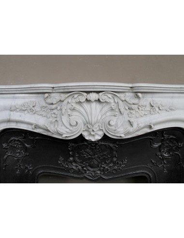 Camino antico barocco con sculture a motivo floreale, d'eccezionale raffinatezza, provvisto di controcuore in ghisa d'arte.