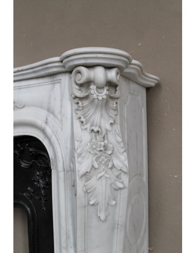 Camino antico barocco in marmo con sculture floreali, d'eccezionale raffinatezza, provvisto di controcuore in ghisa d'arte.