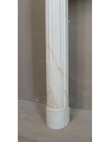 Camino antico neoclassico in marmo con finissime venature dorate su fondo bianco. Un'elegante cornice in marmo da camino.