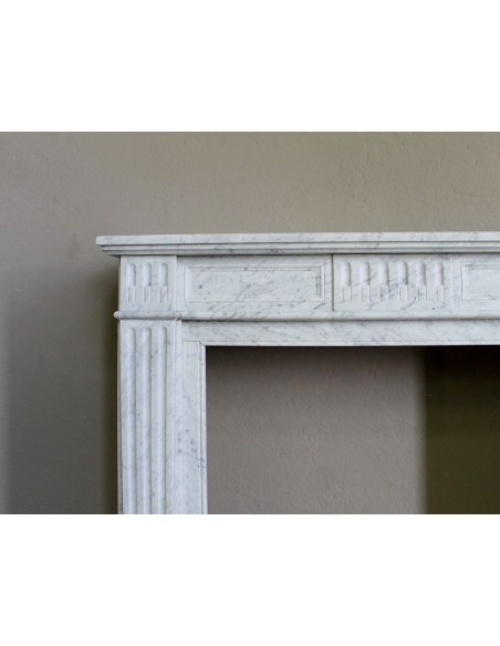 Camino antico neoclassico in maro bianco di Carrara. Questa è una cornice in marmo dalle linee sobrie, pulite, eleganti.