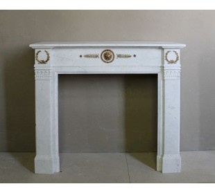 Camino antico neoclassico scolpito in marmo Bianco Carrara con inserti in bronzo dorato raffiguranti foglie d'ulivo e leoni.