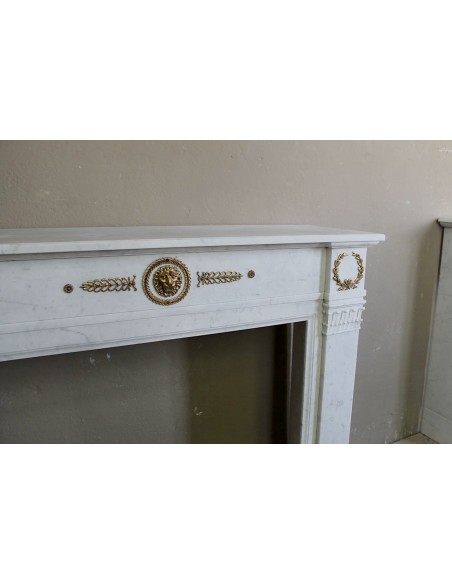 Camino antico neoclassico scolpito in marmo Bianco Carrara con inserti in bronzo dorato raffiguranti foglie d'ulivo e leoni