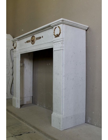 Camino antico neoclassico scolpito in marmo Bianco Carrara con inserti in bronzo dorato raffiguranti foglie d'ulivo e leoni