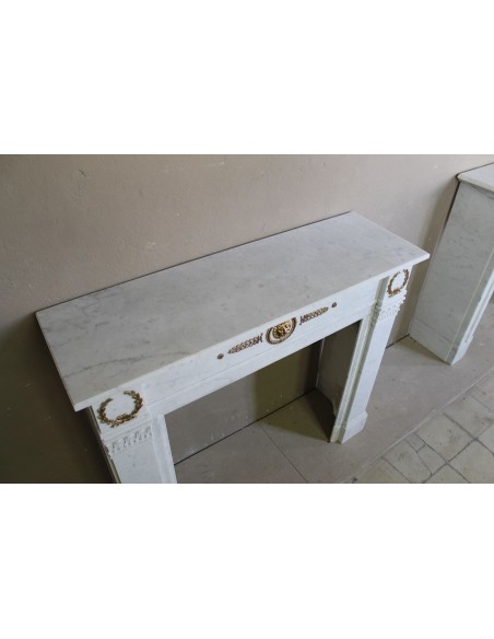 Camino antico neoclassico scolpito in marmo Bianco Carrara con inserti in bronzo dorato raffiguranti foglie d'ulivo e leoni