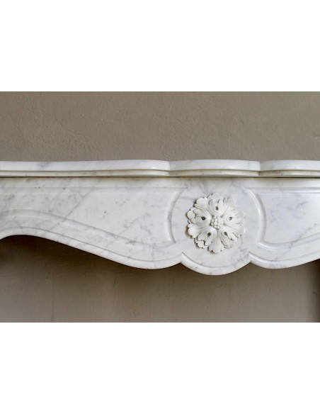 Caminetto antico barocco "Pompadour" scolpito in marmo bianco Carrara recante la scultura di una rosa al centro del frontale.