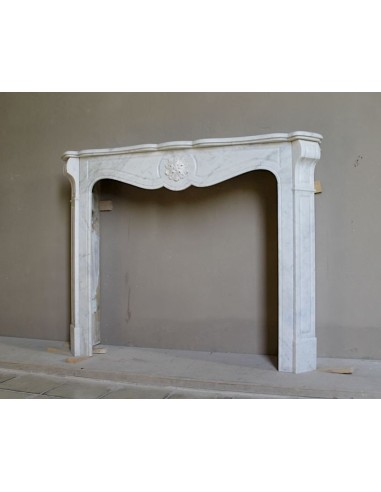 Caminetto antico barocco "Pompadour" scolpito in marmo bianco Carrara recante la scultura di una rosa al centro del frontale.
