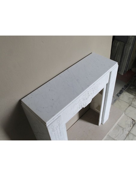 Camino antico di stile ed epoca Art Deco, iconico nell'architettura e con decori floreali, scolpito in marmo bianco Carrara.