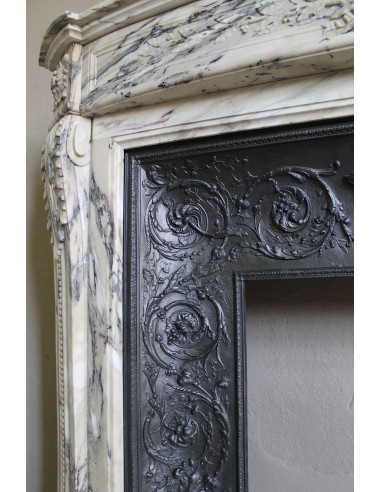 Camino neoclassico in marmo Statuario venato con toni dal bianco al beige al viola, provvisto di controcuore in ghisa d'origine.