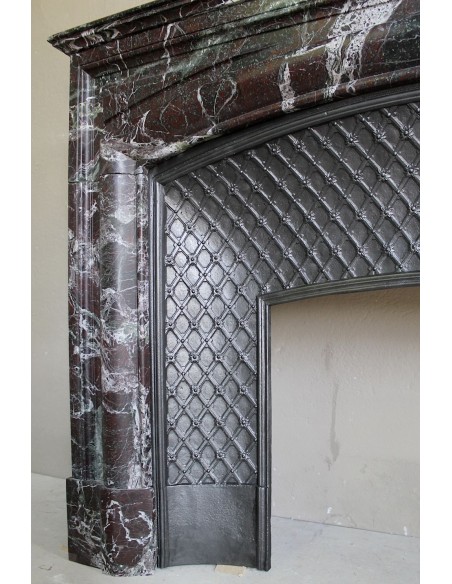 Camino antico in marmo Levanto caratterizzato da tonalità cromatiche che sfumano tra il rosso, il verde, il viola, il bianco.