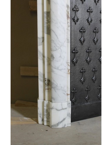 Camino antico "Boudin Haut" scolpito in marmo Calacatta bianco venato provvisto di controcuore in ghisa a "tapisserie".