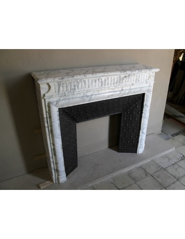 Camino antico "Boudin Haut" scolpito in marmo Calacatta bianco venato provvisto di controcuore in ghisa a "tapisserie".