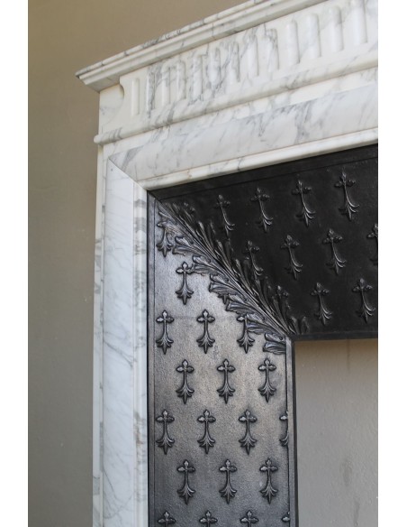 Camino antico "Boudin Haut" scolpito in marmo Calacatta bianco venato provvisto di controcuore in ghisa a "tapisserie".