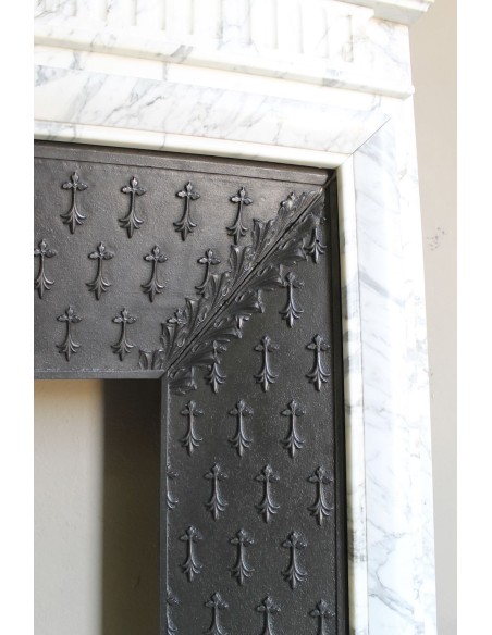 Camino antico "Boudin Haut" scolpito in marmo Calacatta bianco venato provvisto di controcuore in ghisa a "tapisserie".