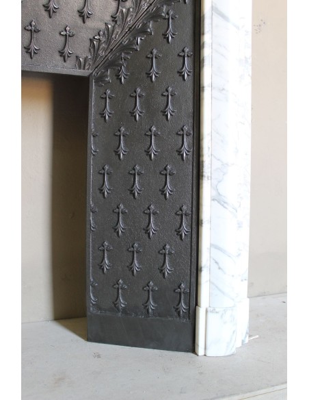 Camino antico "Boudin Haut" scolpito in marmo Calacatta bianco venato provvisto di controcuore in ghisa a "tapisserie".