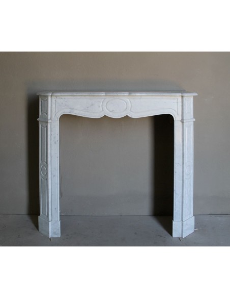 Cornice da camino scolpita in marmo bianco di Carrara. Questo caminetto è antico ed autentico, di stile Luigi XV.