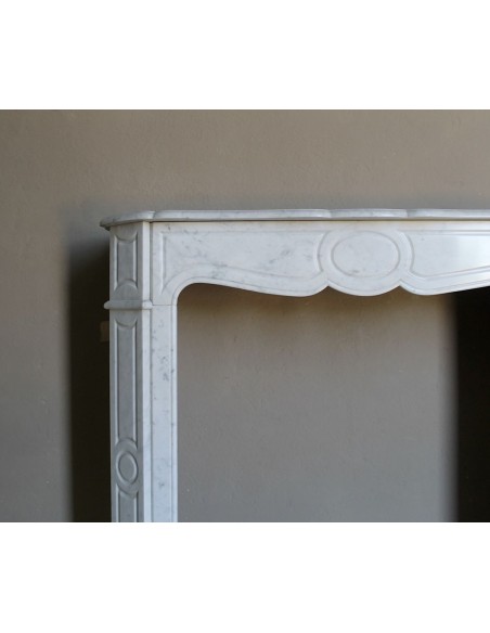 Cornice da camino scolpita in marmo bianco di Carrara. Questo caminetto è antico ed autentico, di stile Luigi XV.