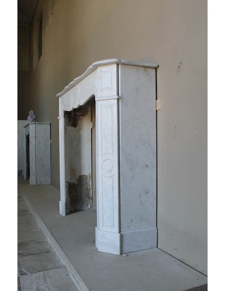 Cornice da camino scolpita in marmo bianco di Carrara. Questo caminetto è antico ed autentico, di stile Luigi XV.
