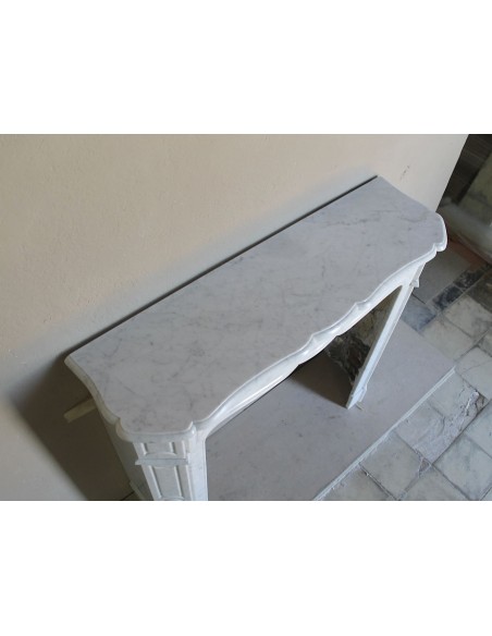 Cornice da camino scolpita in marmo bianco di Carrara. Questo caminetto è antico ed autentico, di stile Luigi XV.