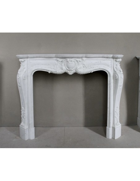 Camino antico in marmo bianco di stile barocco e d'epoca ottocentesca con decori floreali e sculture raffinate.