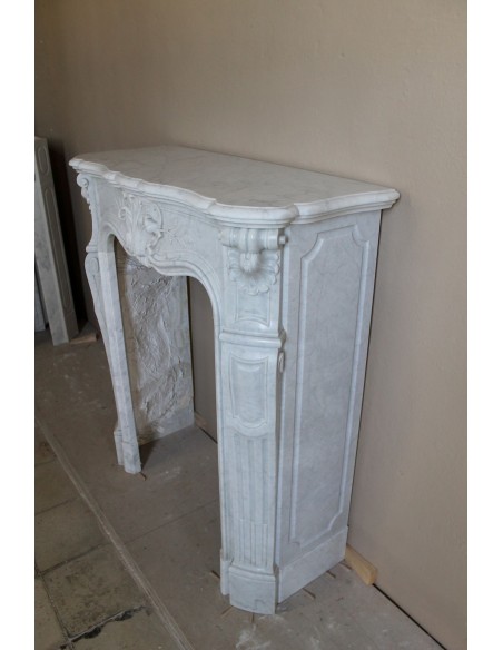 Rarissimo caminetto barocco di piccolissime dimensioni e importante carico decorativo scolpito in marmo bianco di Carrara.