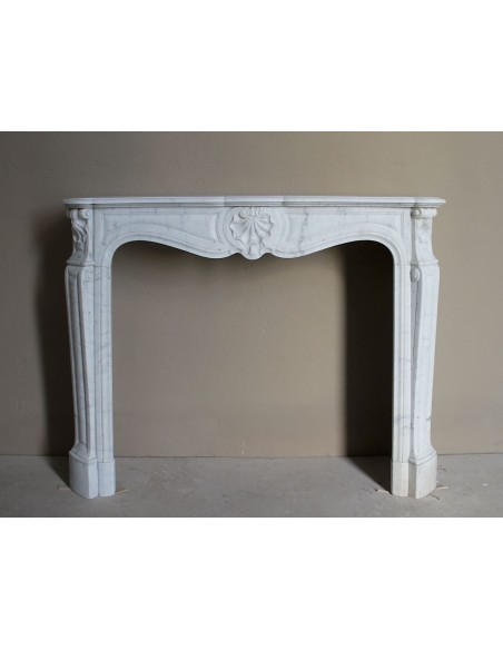 Caminetto Luigi XV "Trois Coquilles" in marmo bianco di Carrara, di stile barocco proposto in offerta ad un prezzo scontato.