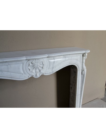 Caminetto Luigi XV "Trois Coquilles" in marmo bianco di Carrara, di stile barocco proposto in offerta a prezzo scontato.