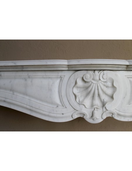 Caminetto Luigi XV "Trois Coquilles" in marmo bianco di Carrara, di stile barocco proposto in offerta a prezzo scontato.