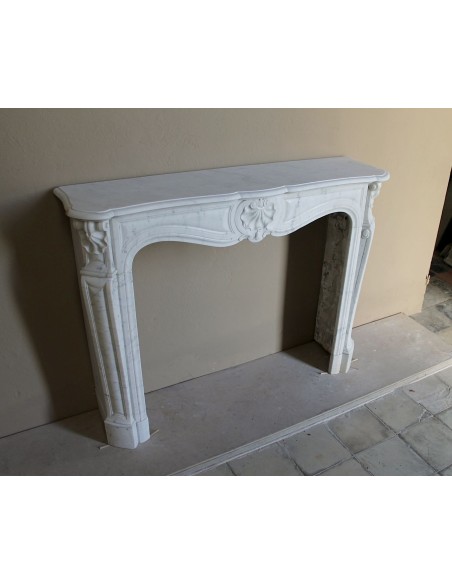Caminetto Luigi XV "Trois Coquilles" in marmo bianco di Carrara, di stile barocco proposto in offerta a prezzo scontato.
