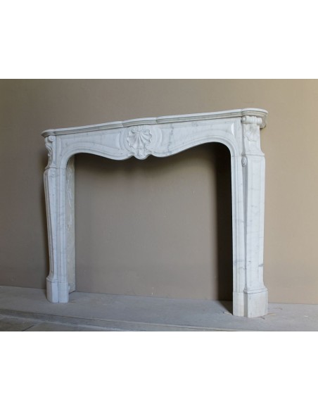 Caminetto Luigi XV "Trois Coquilles" in marmo bianco di Carrara, di stile barocco proposto in offerta a prezzo scontato.