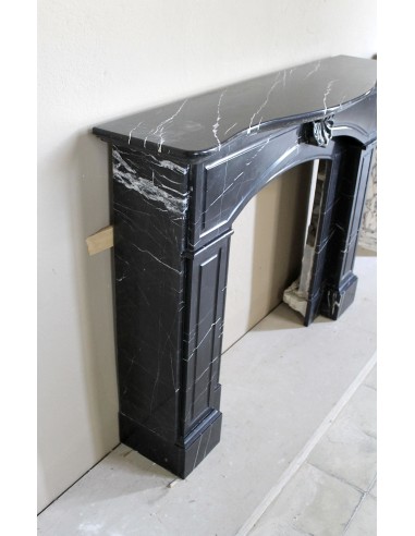 Camino antico di grandi dimensioni scolpito in nero Marquinia, con venature bianche a contrasto, a decoro barocco di conchiglia.