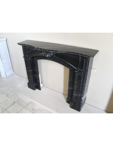 Camino antico di grandi dimensioni scolpito in nero Marquinia, con venature bianche a contrasto, a decoro barocco di conchiglia.