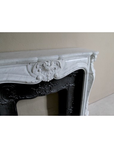 Caminetto Luigi XV floreale scolpito in marmo bianco, con decori floreali a conchiglie, con controcuore originale.