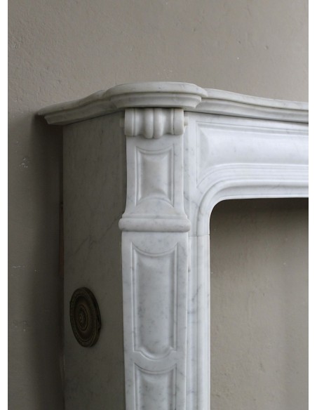 Cornice antica da camino "Pompadour" scolpita in candido marmo bianco Carrara e con bocche in bronzo decorate.